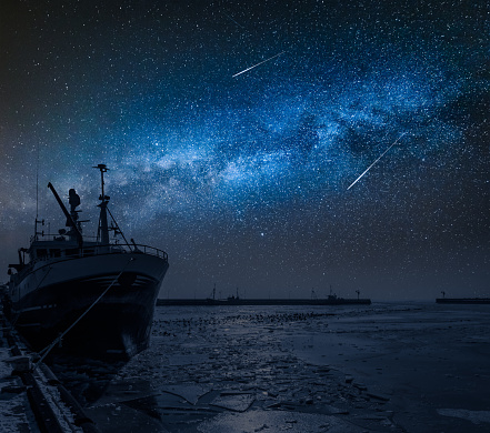 Ship on a frozen sea in winter and milk way