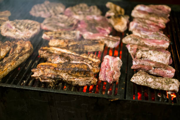 carne jugosa asada cocinada sobre las brasas en una barbacoa en la noche - charbroil fotografías e imágenes de stock