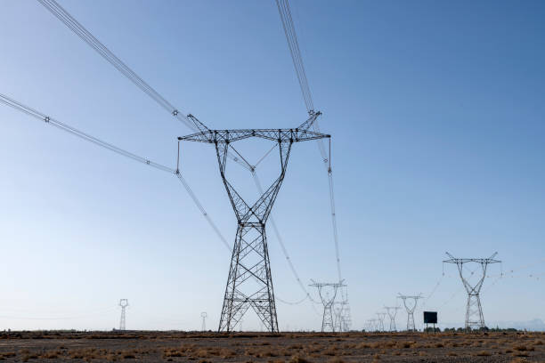 istock High voltage pylons against a blue sky background 1140968058