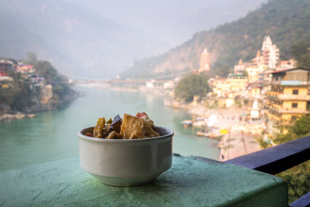 A dish of grilled and stewed vegetables on the background of the river Ganges. Rishikesh India., yoga city India, Gange River Ganga Ram Jhoola Jula