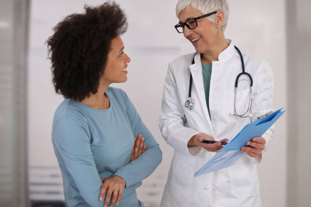 woman doctor and patient talking about medical report good new concept. professional medical help,support, advice female health , gynecology concept - healthcare and medicine stethoscope patient report imagens e fotografias de stock