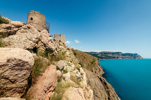 The ruins of an old fortress on a high coast near the sea.