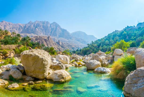 laguna con agua de turquesa en wadi tiwi en omán. - boulder flowing water mountain range rock fotografías e imágenes de stock