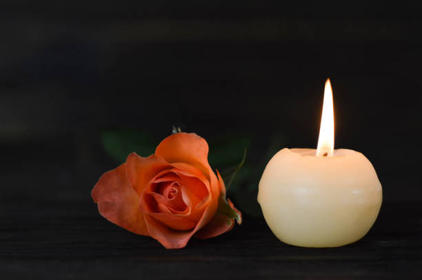 istock Burning candle and rose on dark background 1140980329