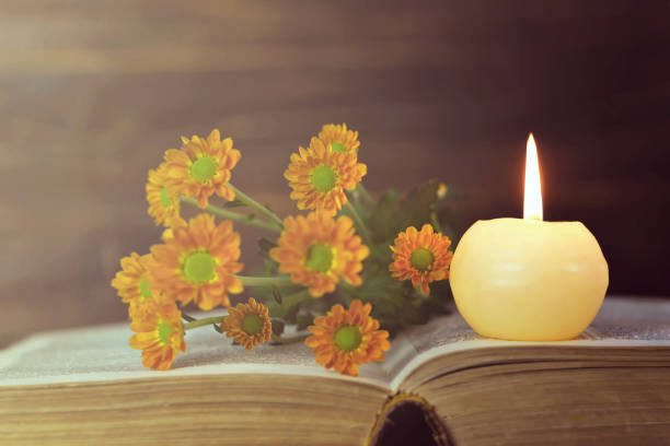 istock Memorial candle, open book and flowers 1140980361