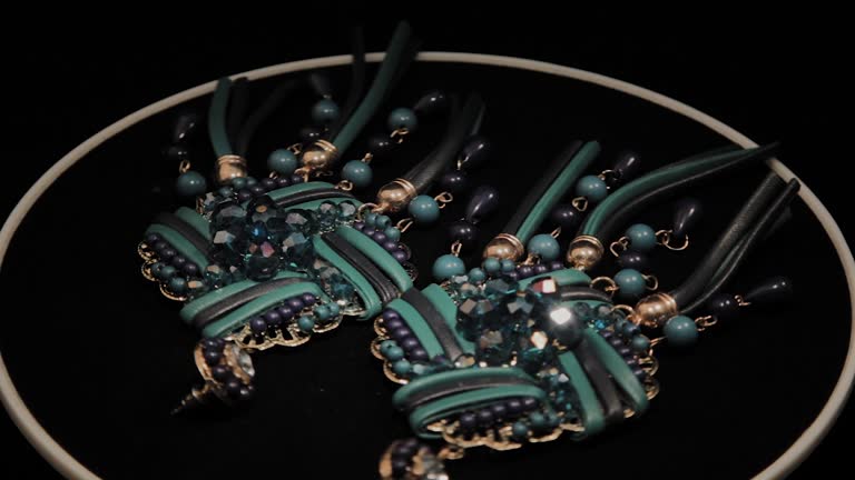 Beautiful female earrings on a black rotating stand. Premium Jewelery. Macro