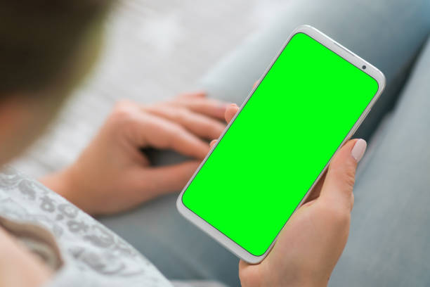 istock Woman's hands holding mobile phone Green screen smartphone. chroma key. close up. Mockup image. 1140983267