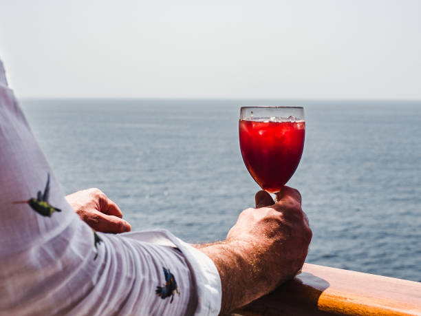 istock Man's hand and glass with a cocktail 1140984649