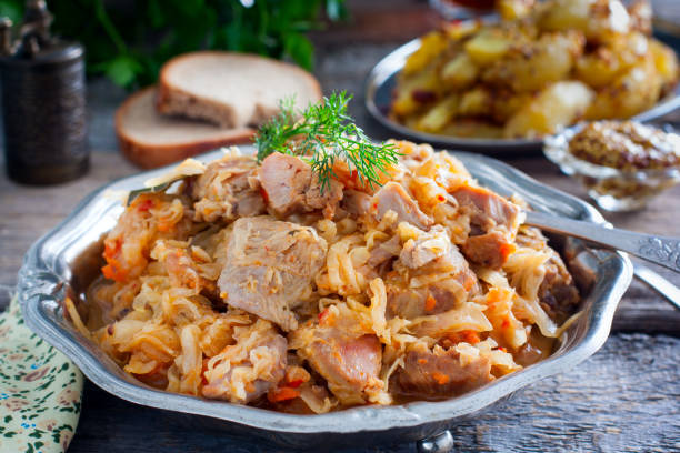 col estofada con carne de muslo de pavo en una mesa de madera, horizontal - bigos fotografías e imágenes de stock