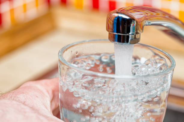 istock Filling up a glass with drinking water from kitchen tap 1140986951