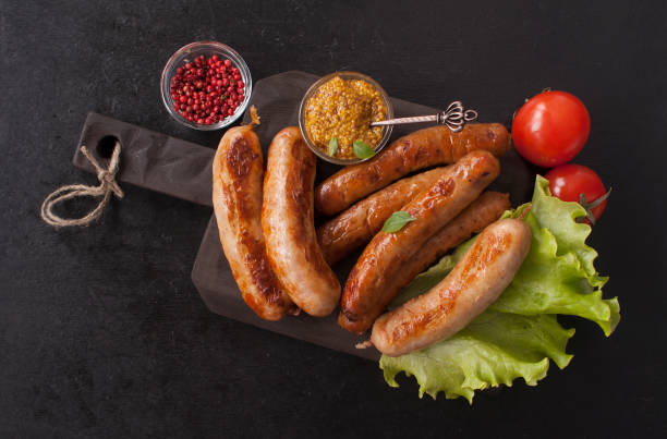 assorted grilled delicious sausages on a wooden kitchen board. copy space. top view - sausage bratwurst barbecue grill barbecue imagens e fotografias de stock