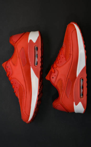istock Red sneakers with white sole, close-up on a black background 1140989601