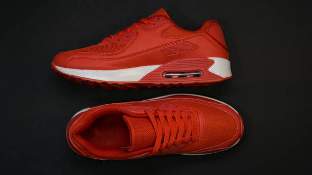 istock Close-up, red sneakers, with white sole, on a black background 1140989701