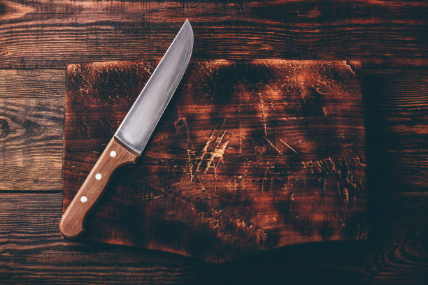 istock Knife over wooden cutting board 1140990657