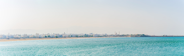View of a beach and a port in the omani city Sur.