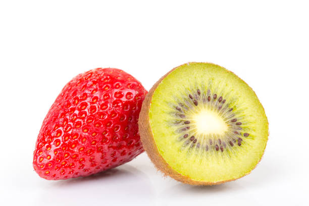 istock Red fresh strawberries and green kiwi cut into half arranged on a white background. 1140998594