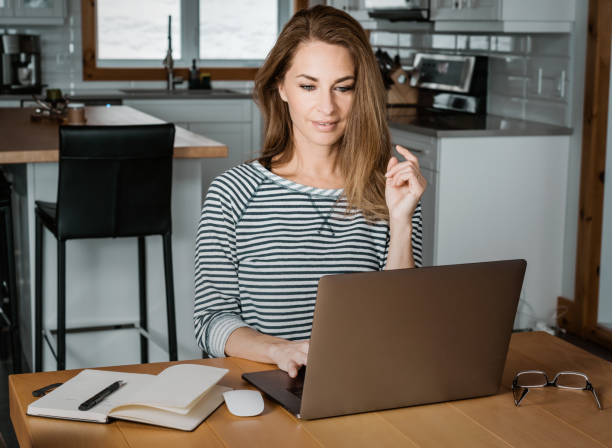 istock middle-aged woman working at home with her computer. 1141001322