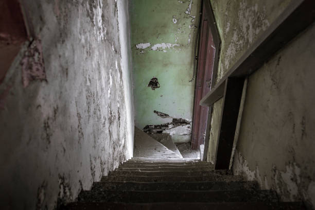 istock Looking down a creepy stairwell with paint peeling off the walls 1141001798