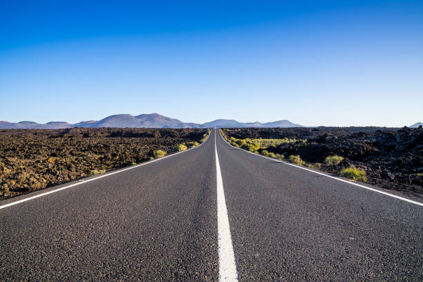 istock Spain, Lanzarote, Country road leading through endless lava fields 1141007549