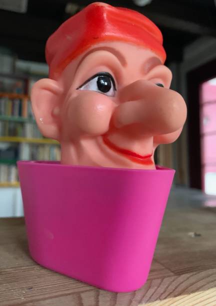 istock Finger punch puppet, clown or fool, books background 1141007843
