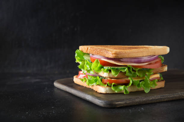 istock Sandwich with bacon,tomato, onion, salad on black background. Isolated. 1141007864
