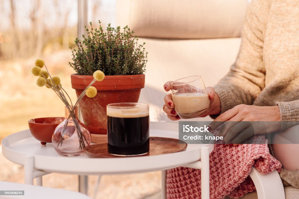 Close up of woman drinking irish coffee liqueur Close up of woman drinking irish coffee liqueur
Woman sitting in greenhouse conservatory in sunlight drinking drink and cofee close up of glass. 30-39 Years Stock Photo