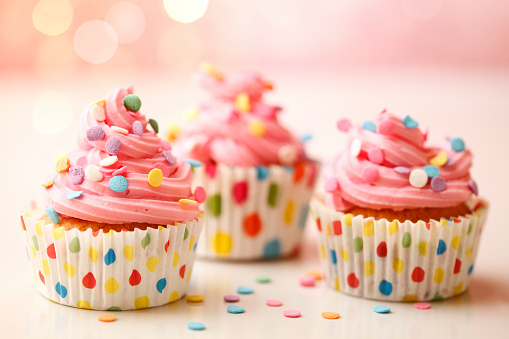 Homemade birthday party cupcakes with colorful polka dots.