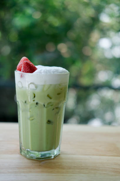 Match green tea latte with fresh strawberry put on wooden tabel