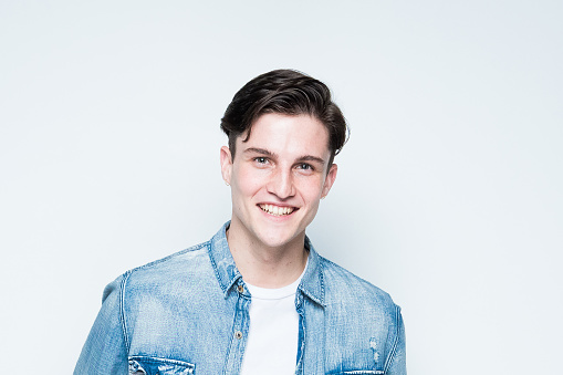 Close up view of attractive man wearing a button down shirtt and is on white background