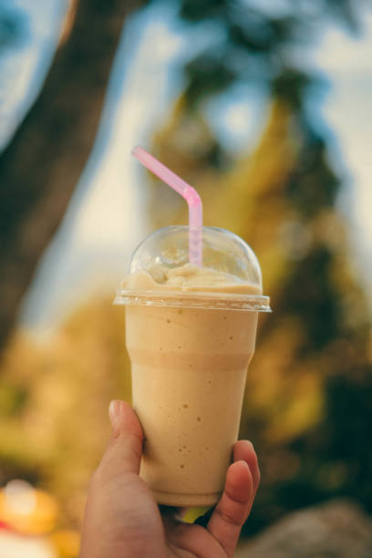 istock Avocado smoothie with blured nature background and holding it 1141009963