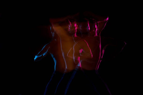 istock Shirtless man dancing with color gel lights 1141009980