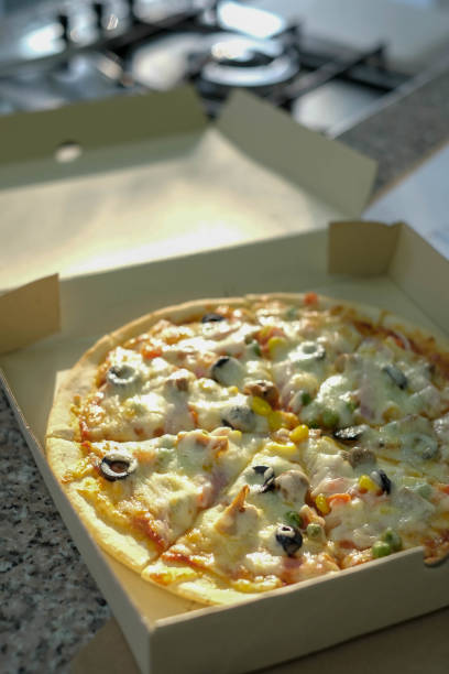 istock pizza in box near stove in kitchen 1141010058