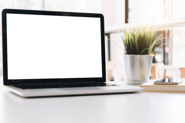 istock Mockup blank screen laptop on workspace table top in living room background 1141010148