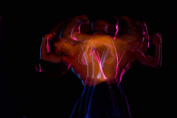 istock Shirtless man dancing with color gel lights 1141010194