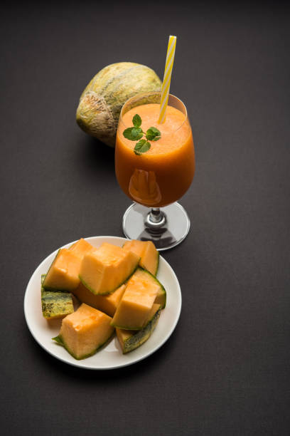Musk melon juice with slice, also known as Kharbuj/kharbuja fruit extract, served in a glass with mint. selective focus