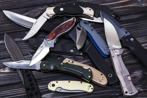 istock Folding knives on a black wooden background 1141014512