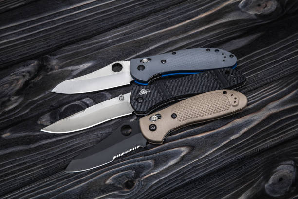istock Folding knives on a black wooden background 1141015445