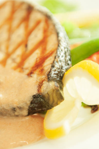 istock Grilled salmon with lemon and salad on white plate. 1141016108