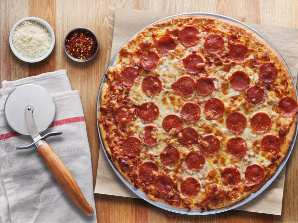 istock large pepperoni pizza on wooden table top down view 1141017411