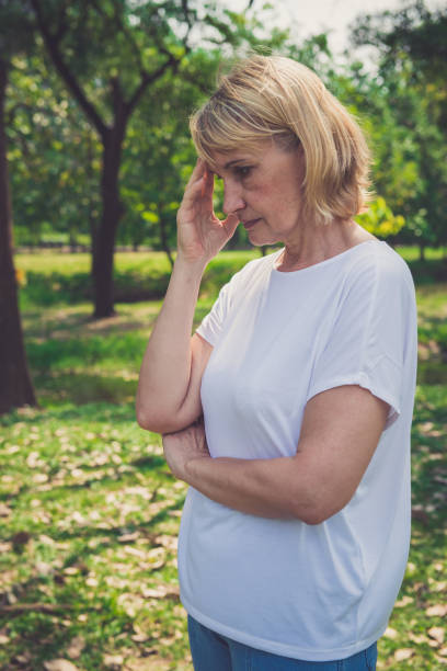 istock Beautiful elderly woman thinking about something in the park 1141019663