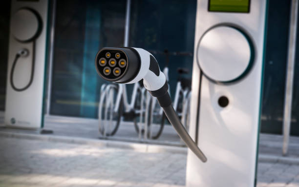 istock Electric Car charging plug with office building background 1141024810