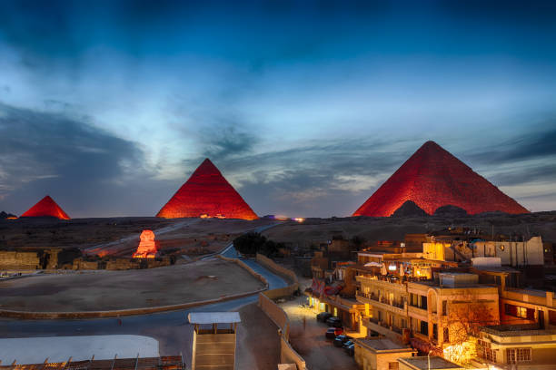 le piramidi di notte, vista dagli edifici di giza, egitto - sphinx night pyramid cairo foto e immagini stock