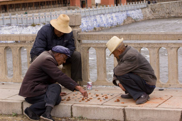 les hommes âgés jouant xiangqi (échecs chinois) un jeu de plateau chinois traditionnel - chinese chess leisure games chinese culture traditional culture photos et images de collection