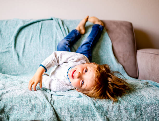 istock Smiling Boy Lays on Couch 1141029426