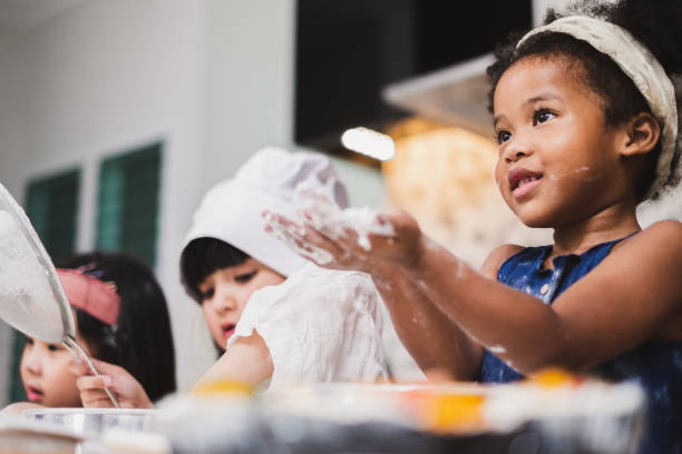 istock Group diversity kids girl making cake bakery in kitchen 1141029609