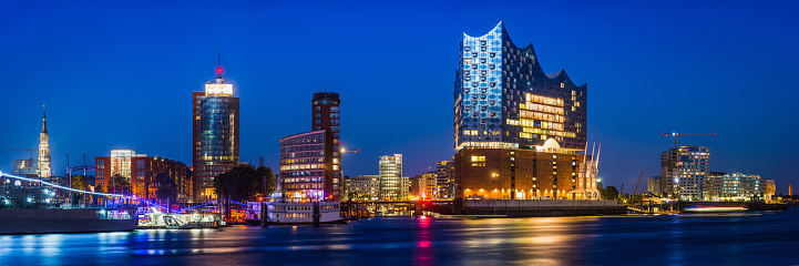Panoramic view across the Elbe to the Elbphilhamonie concert hall and illuminated landmarks of HafenCity, the redeveloped waterfront in the heart of Hamburg, Germany’s vibrant second city.