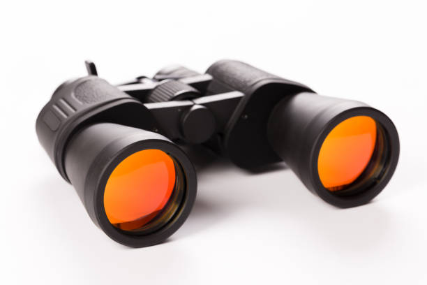 istock Black binoculars with orange lens isolated on white background 1141034837