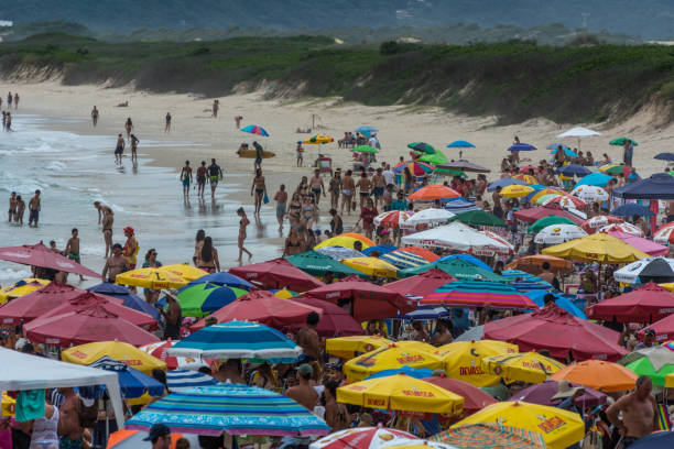 Crowded beach full of umbrellas, in Joaquina Beach, Florianopolis, Brazil. 2019, January. Florianopolis, Brazil. Crowded beach full of umbrellas, in Joaquina Beach. joaquina beach in florianopolis santa catarina brazil stock pictures, royalty-free photos & images