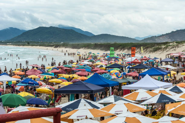 Crowded beach full of umbrellas, in Joaquina Beach, Florianopolis, Brazil. 2019, January. Florianopolis, Brazil. Crowded beach full of umbrellas, in Joaquina Beach. joaquina beach in florianopolis santa catarina brazil stock pictures, royalty-free photos & images