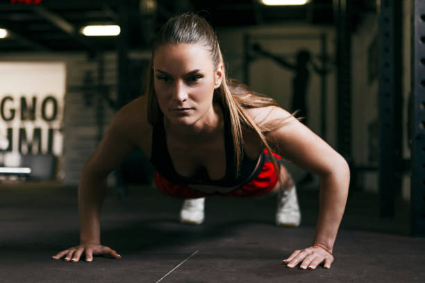 istock Young woman doing push-ups at the gym 1141038309